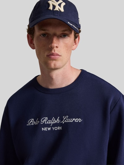 Männermodel trägt dunkelblaues Regular Fit Sweatshirt aus Baumwoll-Mix von Polo Ralph Lauren, weißer Logo-Stick, Nahaufnahme Oberkörper. Herren Sweatshirt von Polo Ralph Lauren
