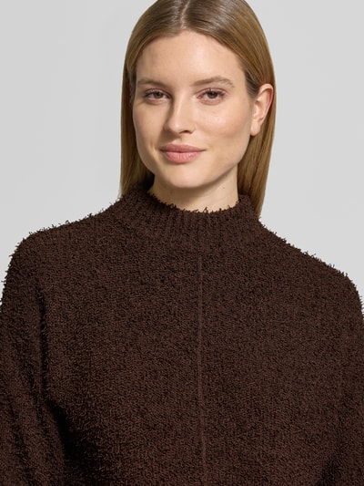 Frauenmodel trägt Pullover mit kleinem Stehkragen Modell 'Punew' von OPUS aus Material-Mix in Braun, gerader Schnitt, gerippte Abschlüsse, Nahaufnahme Oberkörper. Rückenlänge bei Größe 36: 53 cm, Ärmellänge: 45 cm.