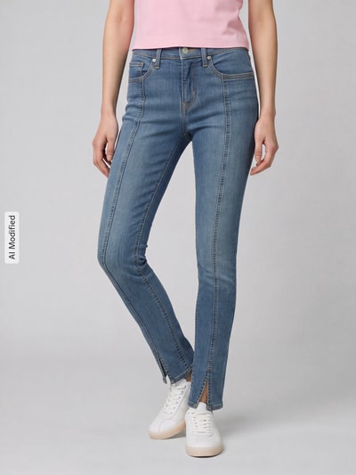 Frauenmodel trägt Skinny Fit Jeans aus Baumwoll-Mix Modell '311 seamed' von Levi's® 300 in hellblau mit sichtbaren Nähten, Ganzkörperansicht von vorne, KI-modifiziertes Bild.