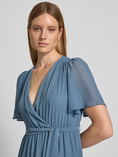 Frauenmodel trägt Abendkleid mit V-Ausschnitt und Bindegürtel von Christian Berg Cocktail aus Chiffon in Blau, Nahaufnahme Oberkörper. Stufen-Look, A-Linie, Maxikleid, Rückenlänge 151 cm, Brustweite 41 cm, Ärmellänge 30 cm.