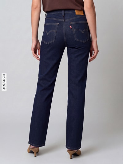 Frauenmodel trägt Straight Fit Jeans aus Baumwoll-Mix mit Lyocell-Anteil Modell '723' von Levi's® 300 in Dunkelblau, Ganzkörperansicht Rückansicht.