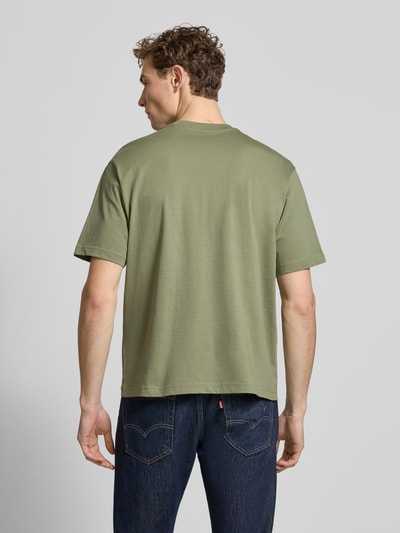 Männermodel trägt Regular Fit T-Shirt aus reiner Baumwolle von MCNEAL in Olivgrün, Rundhalsausschnitt, kurzärmelig; Ganzkörperansicht Rückansicht.
