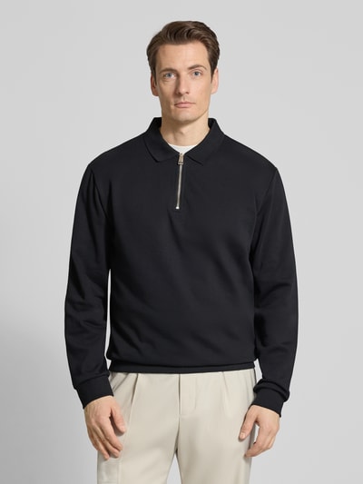 Männermodel trägt Sweatshirt mit Polokragen und Reißverschluss von Lindbergh aus Baumwoll-Mix im Regular-Fit, schwarze Farbe, Ganzkörperansicht von vorne. Rückenlänge bei Größe M: 70 cm.