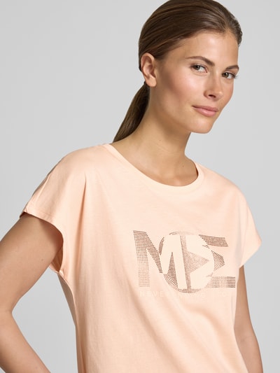 Frauenmodel trägt Regular Fit T-Shirt mit Ziersteinbesatz von monari, Baumwoll-Modal-Mix, Rundhalsausschnitt, Damen T-Shirt, Nahaufnahme Oberkörper. Rückenlänge bei Größe 36: 57 cm.