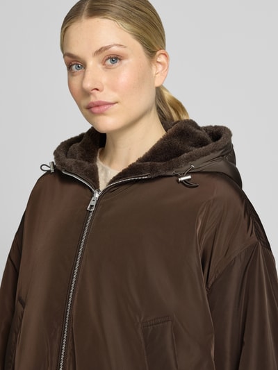 Frauenmodel trägt Relaxed Fit Blouson mit Wendefunktion von Marc O'Polo in Dunkelbraun, glatte Oberfläche, Damen Bomberjacke, Nahaufnahme Oberkörper.