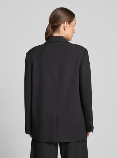 Männermodel trägt czarny żakiet Relaxed Fit z mieszanki materiałów z dodatkiem wiskozy, model 'MOWTIE' od Drykorn, gładka faktura, kieszenie z wypustkami, kołnierz z połami, zapięcie na guzik, długość tyłu w rozmiarze 36: 72 cm, szerokość w rozmiarze 36: 48 cm, długość rękawów w rozmiarze 36: 60 cm, widok całej sylwetki z tyłu