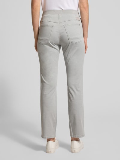 Kobiece modelka ma na sobie spodnie materiałowe z elastycznym pasem Relaxed Fit model 'Pamina' od Raphaela By Brax, szare, mieszanka bawełny, kieszenie wpuszczane i tylne, szerokość w rozmiarze 36K: 35 cm, długość wewnętrzna nogawki: 73 cm, widok całej sylwetki od tyłu.
