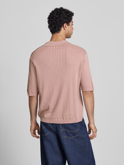 Männermodel trägt Relaxed Fit Poloshirt aus Viskose-Mix Modell 'FLINT' von Only & Sons, Optik: Unifarben, Struktur, Ganzkörperansicht Rückansicht.