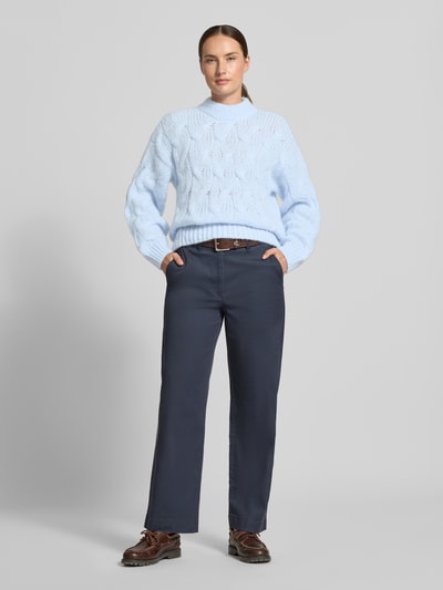 Frauenmodel trägt hellblauen Regular Fit Pullover mit Rundhalsausschnitt Modell 'MAYBE' von VERO MODA, strukturiertes Strickmuster, Ganzkörperansicht von vorne.