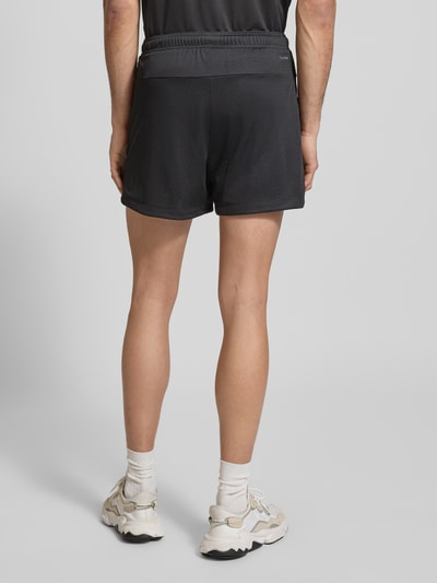 Männermodel trägt Straight Fit Shorts mit Logo-Print in Mesh-Optik von adidas Training, czarny, elastyczny pas, krój straight fit, widok całej sylwetki z tyłu