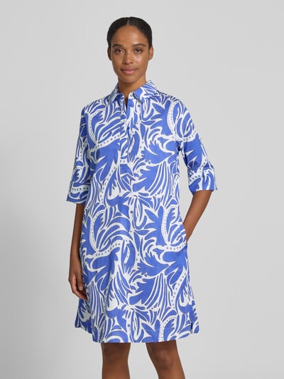 Frauenmodel trägt knielanges Hemdblusenkleid mit verdeckter Knopfleiste von Christian Berg Woman in Weiß und Blau, Reine Baumwolle, Straight Fit, Hemdblusenkragen, 1/2-Arm, strukturierte Oberfläche, Ganzkörperansicht von vorne.