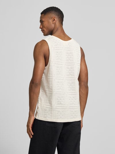 Mężczyznamodel nosi Tanktop mit Rundhalsausschnitt Modell 'Huxley' von Les Deux, bawełniany miks, prosty krój, detal z logo, kolor kremowy, tekstura z geometrycznym wzorem, długość tyłu w rozmiarze M: 65 cm, całkowity widok sylwetki z tyłu.