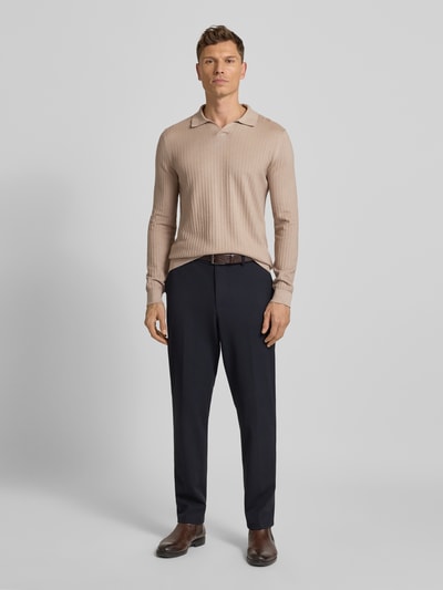 Männermodel trägt Strickpullover mit Umlegekragen Modell 'Galdino' von JOOP! Collection im Baumwoll-Mix, Slim-Fit, Strukturmuster, Label-Detail, beige und dunkelblau, Rückenlänge bei Größe M 73 cm, Ärmellänge 72 cm, Ganzkörperansicht von vorne.
