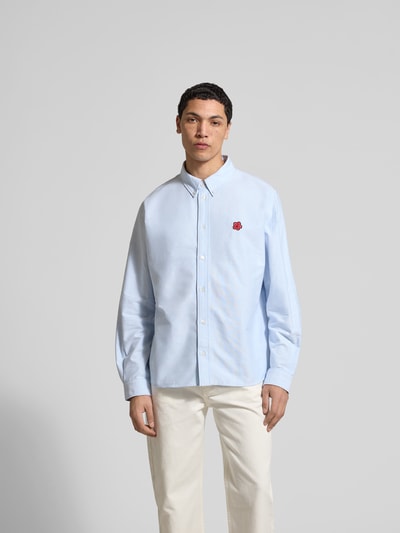 Männermodel trägt Regular Fit Freizeithemd aus Baumwolle von Kenzo, hellblau, Button-Down-Kragen, durchgehende Knopfleiste, Langärmelig, Ganzkörperansicht von vorne. Rückenlänge bei Größe 40: 75 cm, Schulterbreite: 49 cm, Ärmellänge: 66 cm.