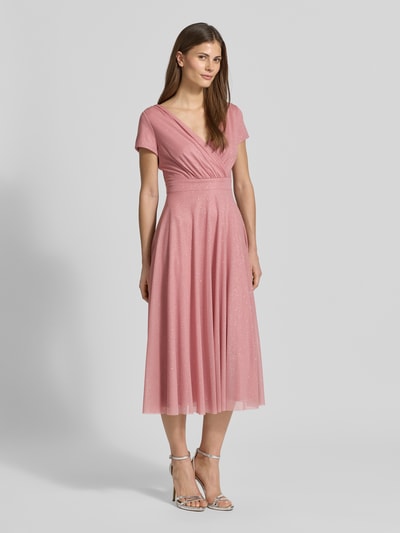 Vrouwenmodel draagt schimmerndes Cocktailkleid mit V-Ausschnitt van Vera Mont, glanzend, tule, A-lijn, midi-jurk, Ganzkörperansicht van voren.
