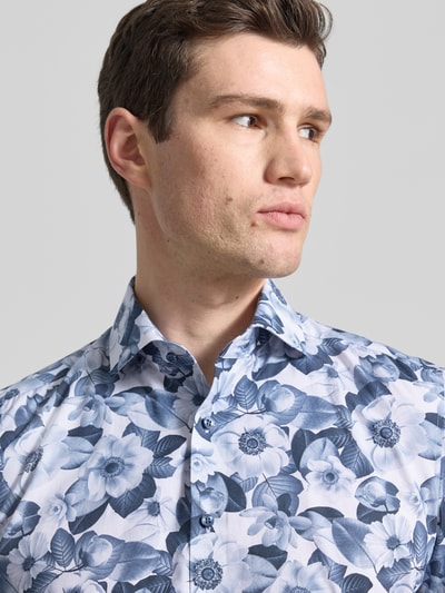 Männermodel trägt Slim Fit Business-Hemd mit Kentkragen und floralem Muster von OLYMP Level Five, reine Baumwolle, Nahaufnahme Oberkörper.