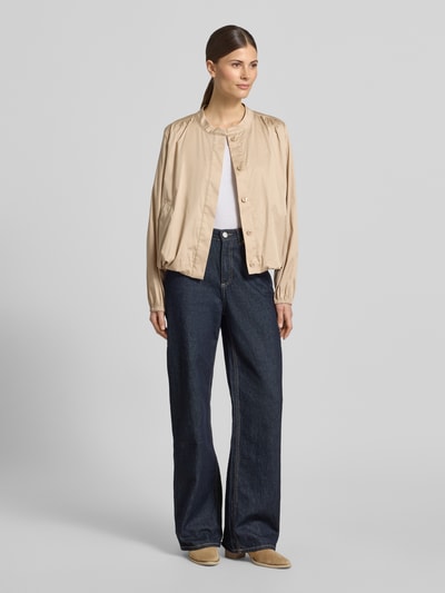Frauenmodel trägt Jacke mit verdeckter Knopfleiste von WHITE LABEL aus Baumwoll-Mix mit Stretch-Anteil in Beige, Regular-Fit, Rundhalsausschnitt, kombiniert mit weiter Jeans und hellen Schuhen, glatte Textur, Rückenlänge bei Größe 36: 55 cm, Brustweite: 58 cm, Ärmellänge: 62 cm. Ganzkörperansicht von vorne.