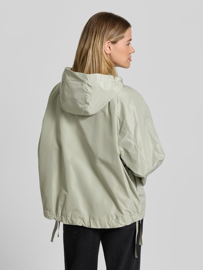 Frauenmodel trägt Jacke mit Kapuze Modell 'CICATA' von CINQUE in hellem Grün, gerader Schnitt, Kordelzug am Saum, Rückenansicht, Ganzkörperansicht.