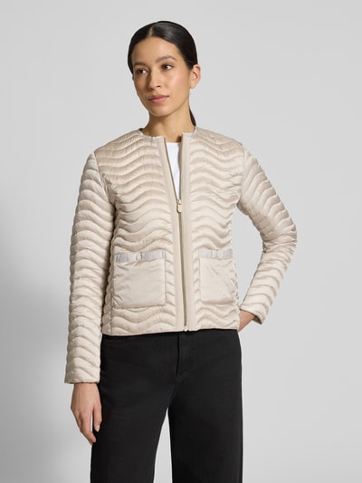 Frauenmodel trägt Slim Fit Steppjacke mit aufgesetzten Taschen Modell 'Tamina' von SAVE THE DUCK, wellige Stepp-Optik, beige, Ganzkörperansicht von vorne