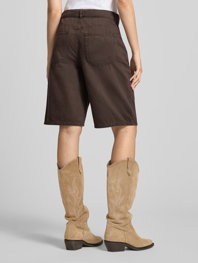 Kobieta modelka ma na sobie szorty jeansowe o kroju regular fit z czystej bawełny model 'MATE-SILLA' od ONLY, widok z tyłu, damskie szorty jeansowe.