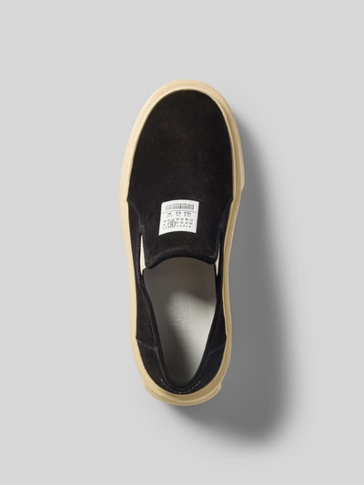 Produktfoto, Sneaker aus echtem Leder von MM6 Maison Margiela mit abgerundeter Passform, Plateau, strukturierter Sohle, schwarzem Obermaterial und Label-Stitching auf hellem Hintergrund.