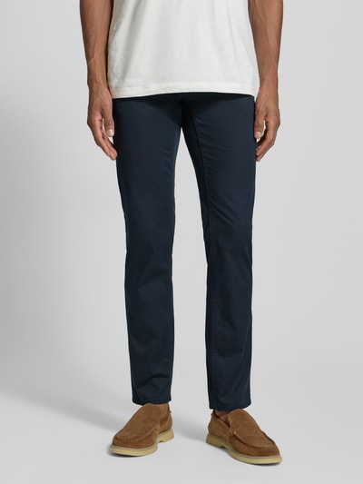 Männermodel trägt Hose mit Eingrifftaschen Modell 'Chuck' von Brax, dunkelblauer Baumwoll-Mix, Slim Fit, Ganzkörperansicht von vorne.