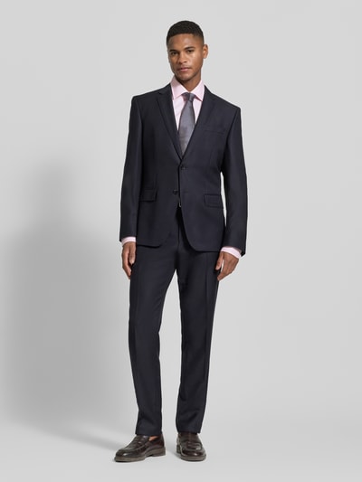 Männermodel trägt Slim Fit Businesshemd mit extra langem Arm Modell 'HANK' von BOSS in Rosa mit Kentkragen, einfarbig, Ganzkörperansicht von vorne.