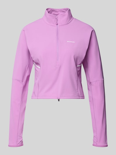 Produktfoto, Sweter o kroju krótki Ein Pullover im Cropped-Design für intensive Anstrengungen od Salomon w kolorze jasnofioletowym, taliowany krój, stójka z ochroną podbródka, half-zip, tunel w pasie, długi rękaw, przeznaczony na zimne dni