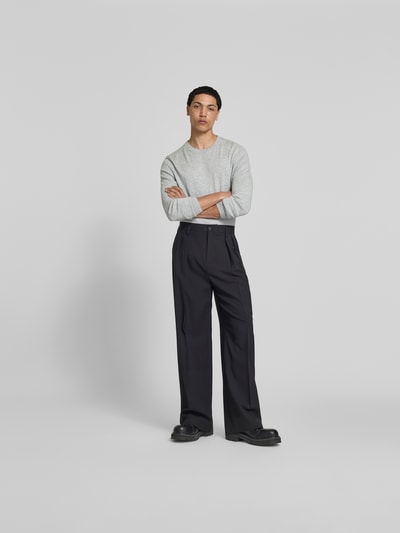 Männermodel trägt Slim Fit Pullover aus Woll-Mix von Filippa K, hellgrau, fein gestrickt, Rundhalsausschnitt, Ganzkörperansicht von vorne.