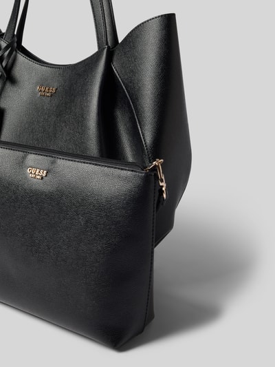 Produktfoto, schwarze Tote Bag in Leder-Optik Modell 'Amorette' von GUESS mit Logo-Detail, schmalen Schulterriemen, Magnetverschluss, nah aufgenommen.