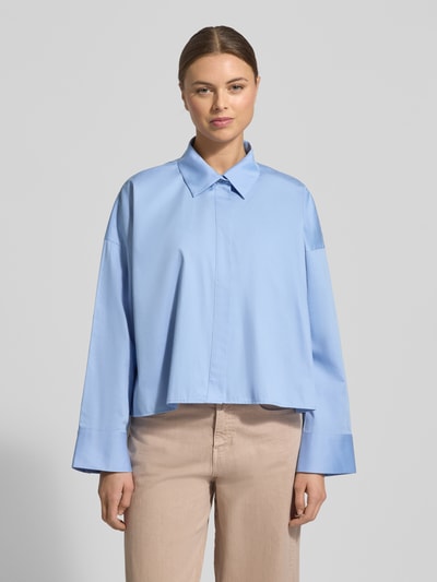 Frauenmodel trägt Hemdbluse mit verdeckter Knopfleiste Modell 'Fundra' von OPUS in Hellblau aus reiner Baumwolle, lockerer Schnitt, Hemdblusenkragen, vorne Ganzkörperansicht.