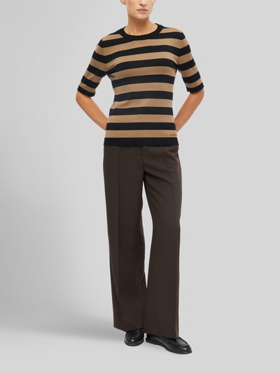 Frauenmodel trägt Regular Fit Pullover aus Viskose-Mix von s.Oliver BLACK LABEL, schwarz-beige gestreift, kombiniert mit brauner Stoffhose, Ganzkörperansicht von vorne. Damen Pullover von s.Oliver BLACK LABEL.