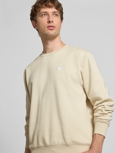 Männermodel trägt Sweatshirt mit Label-Stitching und Rundhalsausschnitt von Nike in Beige, Baumwoll-Mix, Regular-Fit, Nahaufnahme Oberkörper. Rückenlänge bei Größe M: 69 cm, Ärmellänge bei Größe M: 71 cm.