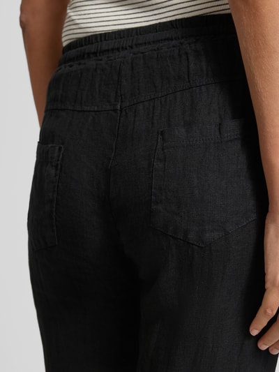 Vrouwenmodel draagt Leinenhose mit elastischem Bund Modell 'Pa44uline' van ZABAIONE, zuiver linnen, regular fit, tunnelkoord, detailopname rug.