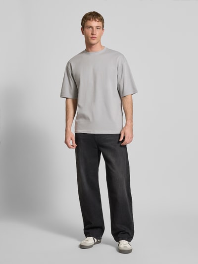 Männermodel trägt Boxy Fit T-Shirt aus Baumwoll-Mix Modell 'CASPIAN AIRFLEX BOXY' von Only & Sons, unifarben, Ganzkörperansicht von vorne.