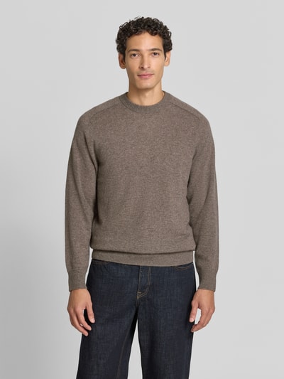 Männermodel trägt Regular Fit Strickpullover aus reinem Kaschmir von FTC Cashmere, braune Farbe, gerippte Abschlüsse, Ganzkörperansicht von vorne.