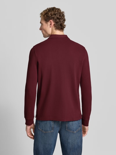 Mannelijk model draagt Regular Fit poloshirt uit puur katoen van MCNEAL in bordeauxrood met Polokraag, knoopsluiting, labelstitching, shirt met lange mouwen, ruglengte bij maat M 73 cm, Ganzkörperansicht Rückansicht.