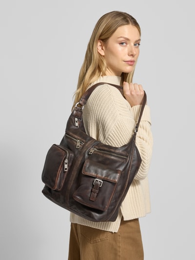 Frauenmodel trägt Handtasche mit diversen Fächern Modell 'ANDREA HOBO' von LIEBESKIND BERLIN in Dunkelbraun, Nahaufnahme Oberkörper. Hauptfach mit Reißverschluss, mehrere Außentaschen, Schulterriemen, strukturierte Leder-Textur, Maße: 28x31x14 cm, Riemenlänge 52 cm.