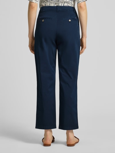 Kobiece model prezentuje Slim Fit Chino aus Baumwoll-Mix von Tommy Hilfiger, efekt: jednolity kolor, krój slim fit, mieszanka bawełny, szlufki na pasek, zapięcie na guzik i zamek błyskawiczny, wpuszczane kieszenie, kieszenie z tyłu, całkowity widok z tyłu.