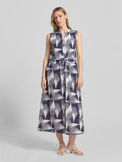Frauenmodel trägt Hemdblusenkleid mit V-Ausschnitt und Bindegürtel Modell 'Lani' von GUIDO MARIA KRETSCHMER WOMAN aus reiner Baumwolle im Allover-Look, blaue und weiße Farben, A-Linie, Midikleid, Knopfleiste, Ganzkörperansicht von vorne.
