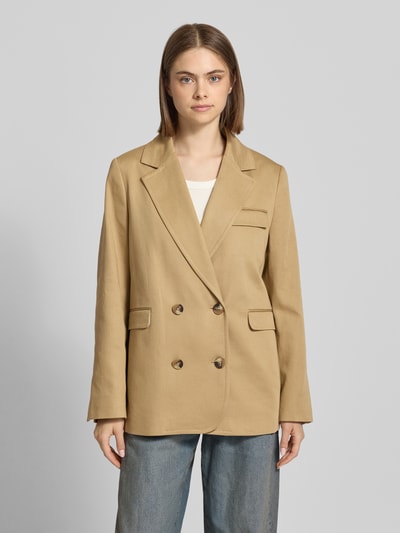 Modelka nosi Regular Fit Blazer mit Doppelknopf-Reihe Modell 'Marlow' von Mustang z bawełny, kolor beżowy, kieszenie z patką, kołnierz z połami, długość tyłu 70 cm, szerokość w rozmiarze S: 39 cm, długość rękawów 63 cm, widok całej sylwetki z przodu.