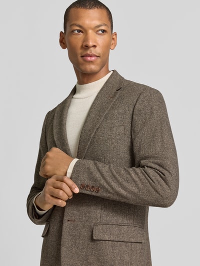Männermodel trägt Slim Fit Sakko mit Pattentaschen aus Wolle von Selected in Braun, Reverskragen, Webware, Nahaufnahme Oberkörper.
