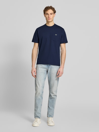 Männermodel trägt Regular Fit T-Shirt aus reiner Baumwolle von Lacoste, Optik: Unifarben, Logo-Stitching, Label-Print, Rundhals, Ganzkörperansicht von vorne