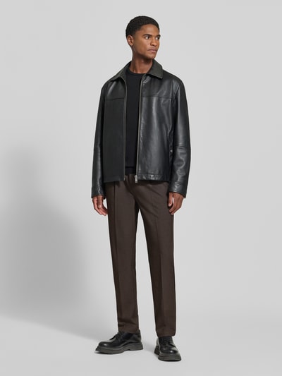 Männermodel trägt Hose mit elastischem Bund und Bügelfalten Modell 'MARC 2.0' von Casual Friday in Braun, Material-Mix mit Viskose-Anteil, Regular Fit, sichtbare Bügelfalten, Eingrifftaschen, Paspeltaschen am Gesäß, Ganzkörperansicht von vorne.