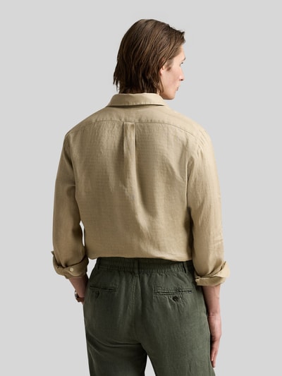 Męski model nosi Slim Fit Freizeithemd aus reinem Leinen od Polo Ralph Lauren, jasnobeżowy, krój slim fit, widok całej sylwetki z tyłu.