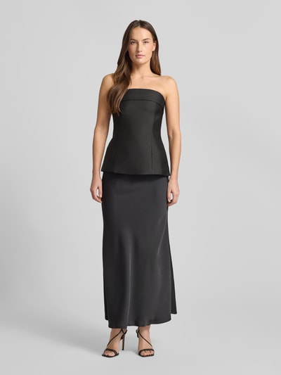 Modelka kobieca nosi Top aus Satin im Ärmellosen Design Modell 'Taleen' od Neo Noir, czarny satynowy, dopasowany krój, zdjęcie całopostaciowe z przodu.