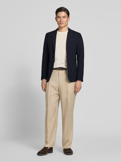 Männermodel trägt Slim Fit 2-Knopf-Blazer mit Reverskragen von MARKUP, dunkler Material-Mix mit Stretch-Anteil, aufgesetzte Taschen, Ganzkörperansicht von vorne. Rückenlänge 70 cm, Schulterbreite 40 cm, Ärmellänge 65 cm bei Größe 50.