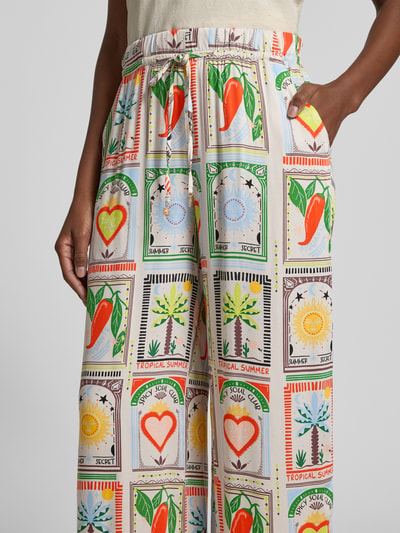 Frauenmodel trägt Stoffhose im Allover-Look mit elastischem Bund von Smith and Soul aus reiner Viskose, Relaxed-Fit, Tunnelzug, buntes Muster, Nahaufnahme Oberkörper.
