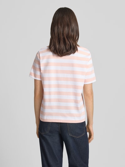 Kobiece model nosi damski t-shirt Boxy Fit T-Shirt aus reiner Baumwolle Modell 'ESSENTIAL' od Selected Femme, efekt: wzór w paski, krój: pudełkowy, naszywka z logo, okrągły dekolt, rękaw: krótki, wykończenie materiału: heavy jersey, materiał: czysta bawełna, kolor różowy i biały, tekstura gładka, całkowity widok z tyłu.