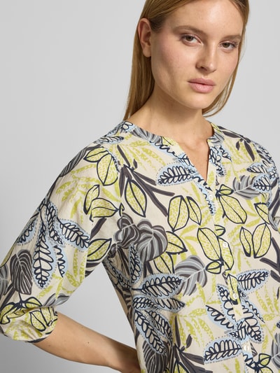 Frauenmodel trägt Regular Fit Bluse mit floralem Allover-Print von Soyaconcept aus reiner Baumwolle, Tunika-Ausschnitt, Knopfleiste, Nahaufnahme Oberkörper.